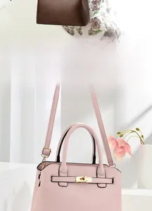 Detail of dark brown and light pink leather handbags with golden twist locks and straps