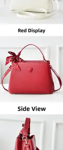 Detail view of red bridal bucket bag with leather heart pattern and decorative scarf
