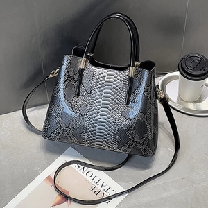 Fashionable black snake-pattern leather handbag with dual handles and slim shoulder strap