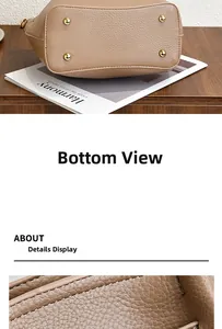 Close-up of brown lychee grain leather bag base with four golden metal feet and fine stitching