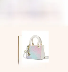 Close-up of pastel gradient handbag with floral embossing and metal D-letter charm