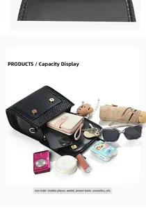 Detail view of black textured crossbody bag with gold buckle showing spacious interior storage
