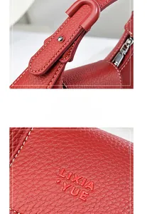Détails du sac à main rouge en cuir litchi montrant les coutures et les rivets