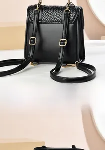 Back view of black leather mini backpack showing woven texture and gold hardware details
