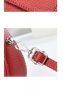 Détail du sac à main en cuir grainé rouge avec boucle argentée et surpiqûres blanches