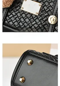 Detail of woven leather texture, gold logo plaque, and protective base studs on black bag