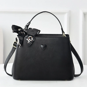 Elegant black leather bucket bag with heart relief and decorative silk scarf handle