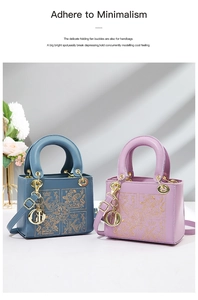 Detail showing elegant gold embroidery and letter D charm on ladies handbag