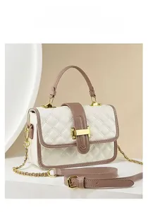 Detail of pink and white quilted crossbody bag with gold rectangular metal buckle closure
