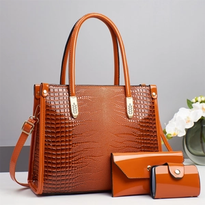 Three-piece orange faux crocodile leather bag set including tote, envelope clutch, and card holder