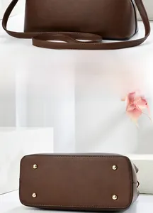 Rear view of dark brown leather handbag with gold metal protective feet on base