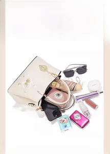 Detailed interior storage view of off-white handbag with golden floral embroidery