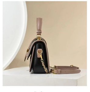 Detail view of two-tone quilted leather handbag with gold chain and pink shoulder strap