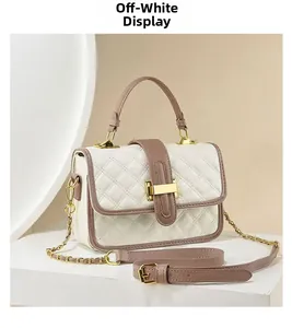 Close-up of off-white quilted handbag with golden square lock and brown leather handle