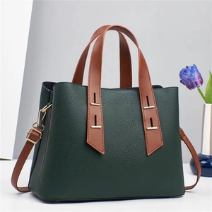 Vue détaillée du sac en cuir vert foncé avec poignées marron et finitions dorées