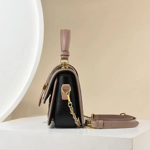 Elegant quilted leather crossbody bag in black and beige contrast with gold chain strap