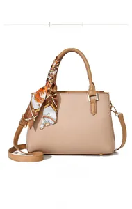 Vista frontale della borsa beige martellata con manici marroni ed elegante foulard di seta