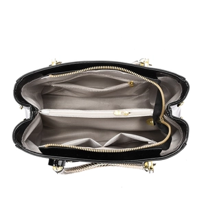 View of patent leather tote interior with three-compartment layout and gold zipper