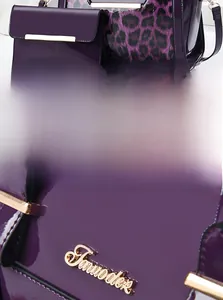 Detailed macro view of purple leopard print tote bag with gold logo hardware and strap