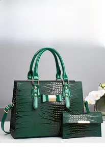 Detail of dark green crocodile pattern leather handbag set with gold hardware and bow