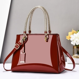 Glossy burgundy patent leather handbag with gold hardware and woven handle