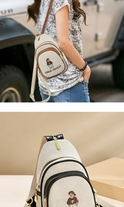 Close-up of canvas chest bag with bear embroidery and leather piping detail