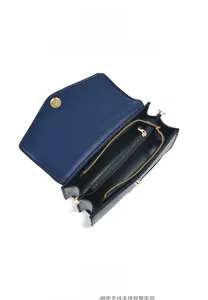 Detail view of the spacious inner compartments of the navy leather handbag with gold hardware