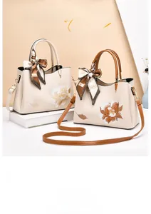 Detail of cream handbags with floral embroidery and decorative printed silk scarves