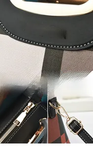 Detail of plaid patterned handbag featuring gold hardware and a brand metal logo