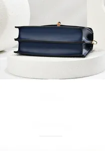 Detail view of the accordion pleated side and navy blue leather base on the handbag