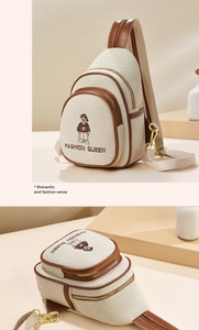 Close-up of bear embroidery and multiple zipper details on a beige canvas chest bag