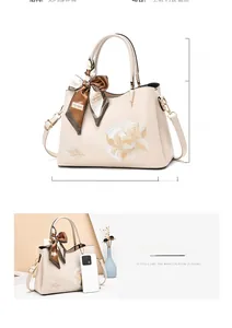 Detail view of cream PU leather handbag showing 28cm width and floral embroidery design