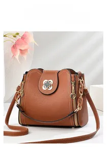 Detail of brown litchi pattern leather bucket bag with gold clover twist lock