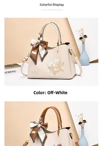 Detailed embroidery of white flowers and silk scarf handle on cream faux leather handbag