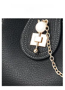 Detail shot of black crocodile texture leather with gold hardware and white stitching