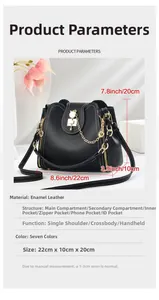 Detail of black textured bucket bag with white stitching and gold pearl chain strap