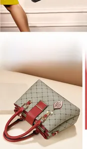 Détail du sac à main gris à motifs avec anses en cuir rouge et breloque dorée