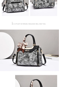 Detail of floral patterned tote bag featuring a leather wrap handle and gold hardware