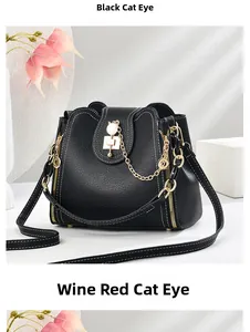 Close-up of litchi leather bucket bags with cat-ear metal locks and gold chain straps