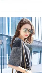 Gros plan de lunettes aviateur dorées avec monture métallique et double pont sur modèle