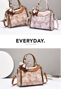 Detail of floral embossed handbag with silk scarf handle and golden zipper hardware