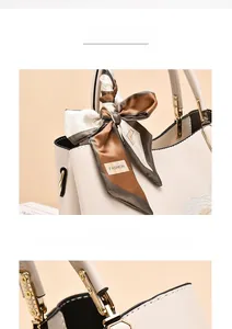 Close-up of beige tote with floral embroidery, scarf-wrapped handle and gold hardware