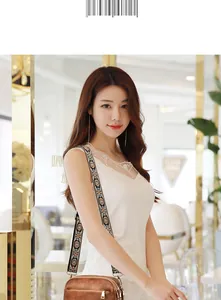 Brown leather crossbody bag with a floral patterned wide strap worn by a model