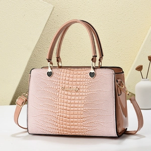 Rosafarbene Schultertasche mit Krokodilprägung, Metall-Logo und zwei Griffen in 45-Grad-Ansicht