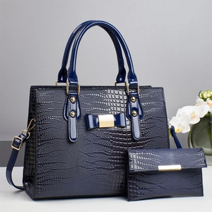 Navy blue lizard pattern handbag with matching wallet and golden bow detail