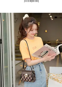 Elegant lady with brown monogram crossbody bag in a stylish cafe setting