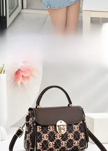 Detail of contrast print satchel with gold metal lock and adjustable shoulder strap