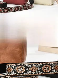 Close-up of vintage wide woven shoulder straps with geometric embroidery on leather bags