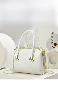 Detailed view of white textured doctor bag with golden metal frame and pearl clasp