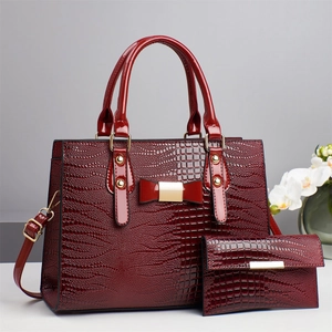 Burgundy faux lizard skin handbag set with matching wallet and golden bow detail